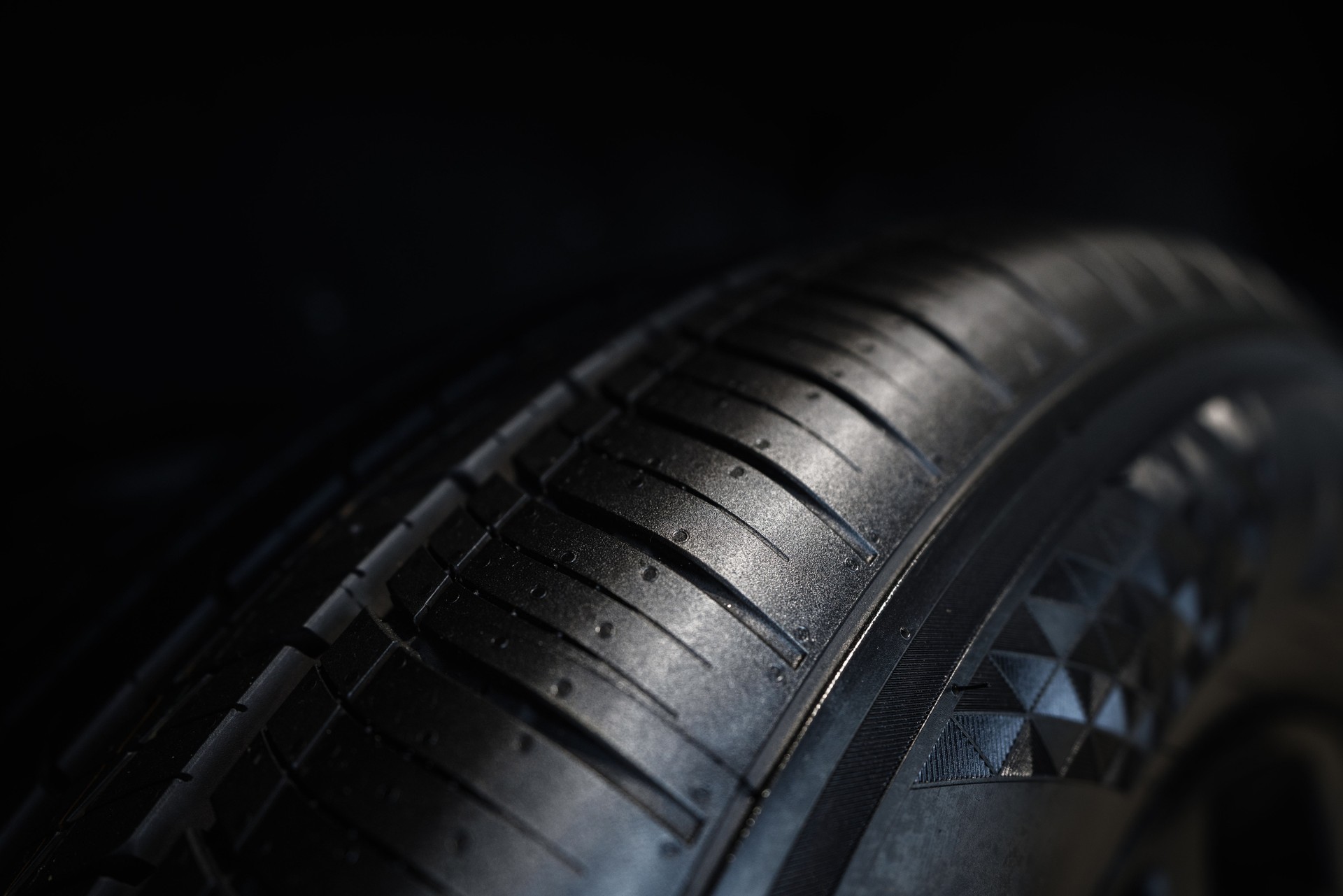 Close-Up View of Modern Tire Tread Pattern on a Black Background